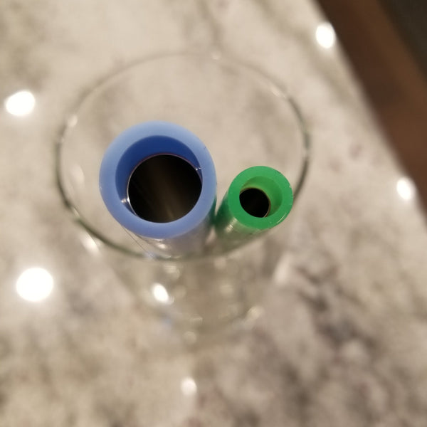 Smoothie size silicone tip next to 1/8" silicone tip on reusable stainless steel straws in glass.
