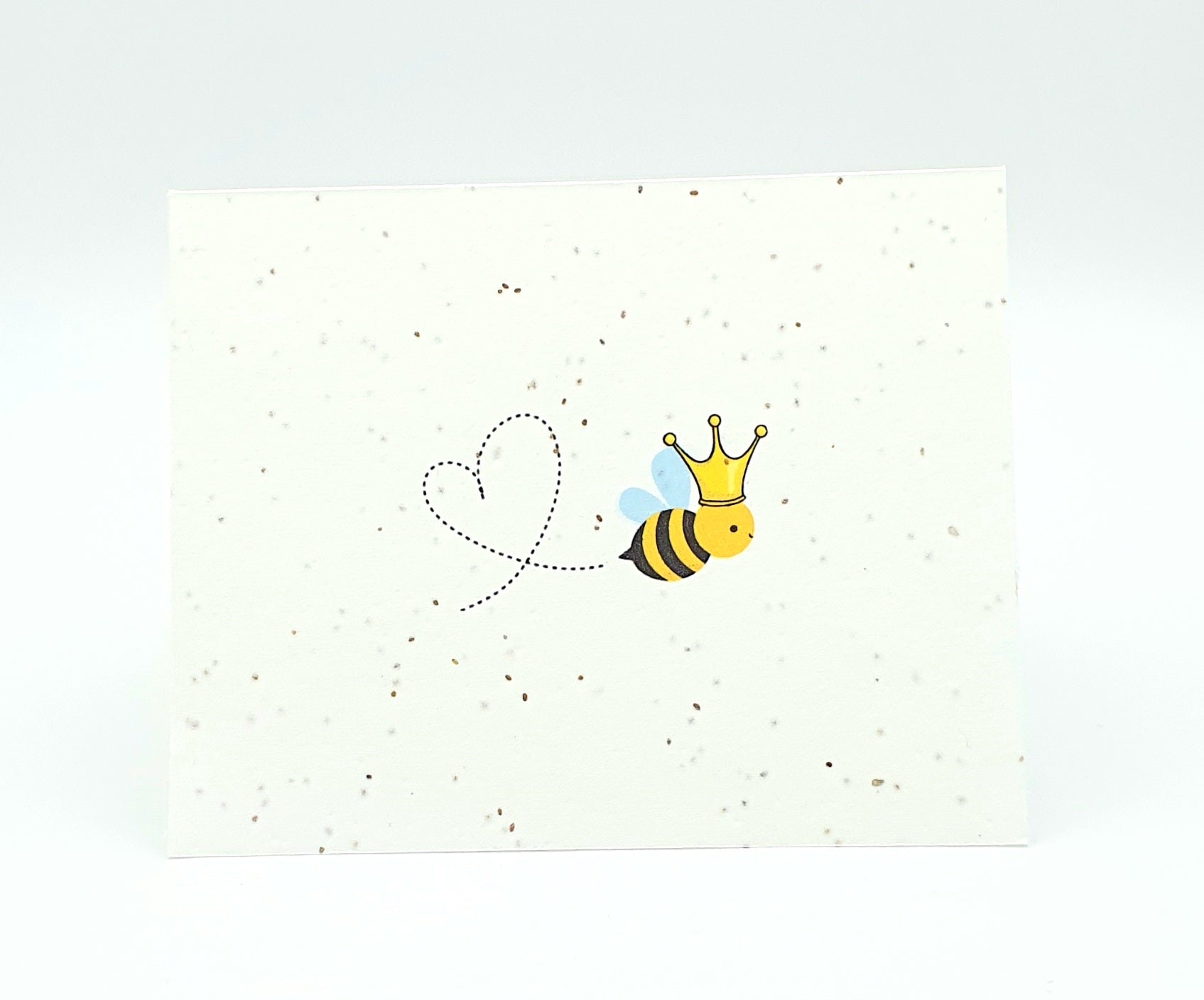 Plantable seed card bee with a crown and making a heart trail