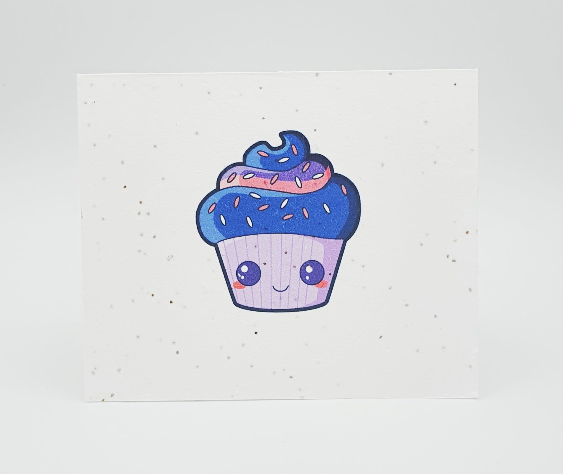 Plantable seed paper card with purple cupcake with face on it.