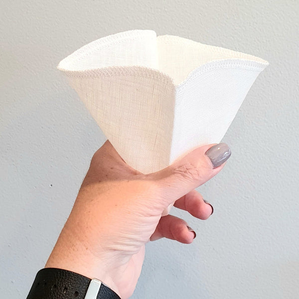 Reusable hemp coffee filter held in a hand.  Size 4.