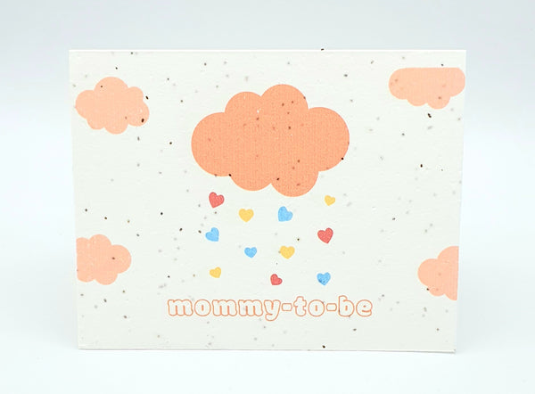 Plantable seed card with peach clouds, hearts raining down "mommy-to-be"