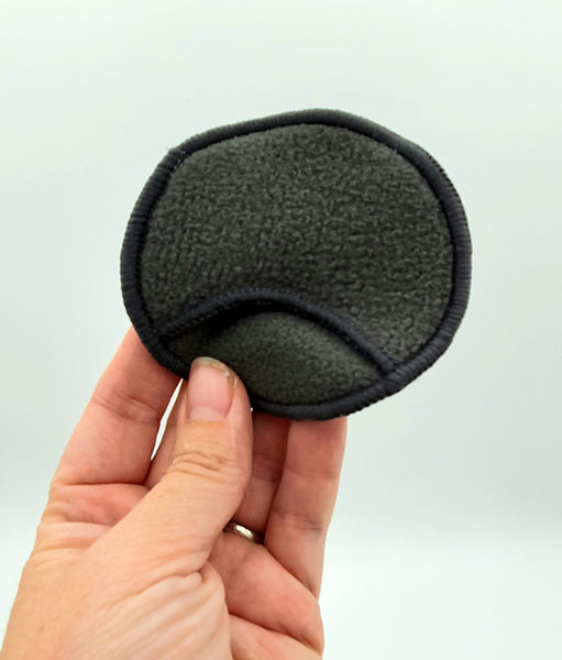 1 bamboo charcoal reusable makeup remover pad held by hand with holding pocket.