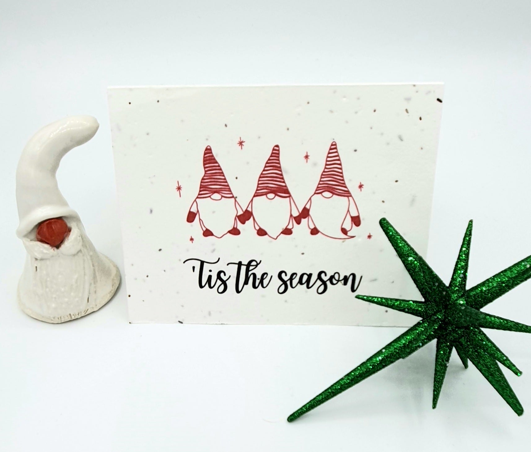 Plantable seed paper card with three red and white gnomes saying Tis the Season.