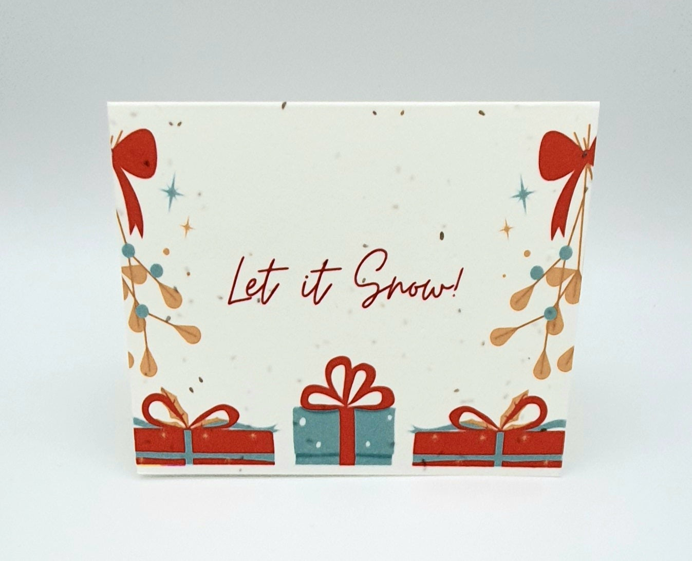 Plantable seed paper card Let is Snow! with red and green gifts.