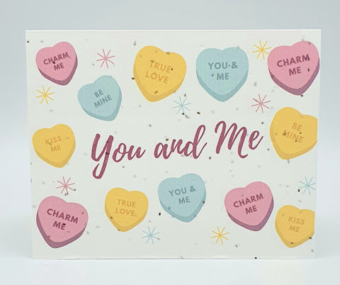 Plantable seed paper card with various coloured candy hearts and mauve text saying You and Me.