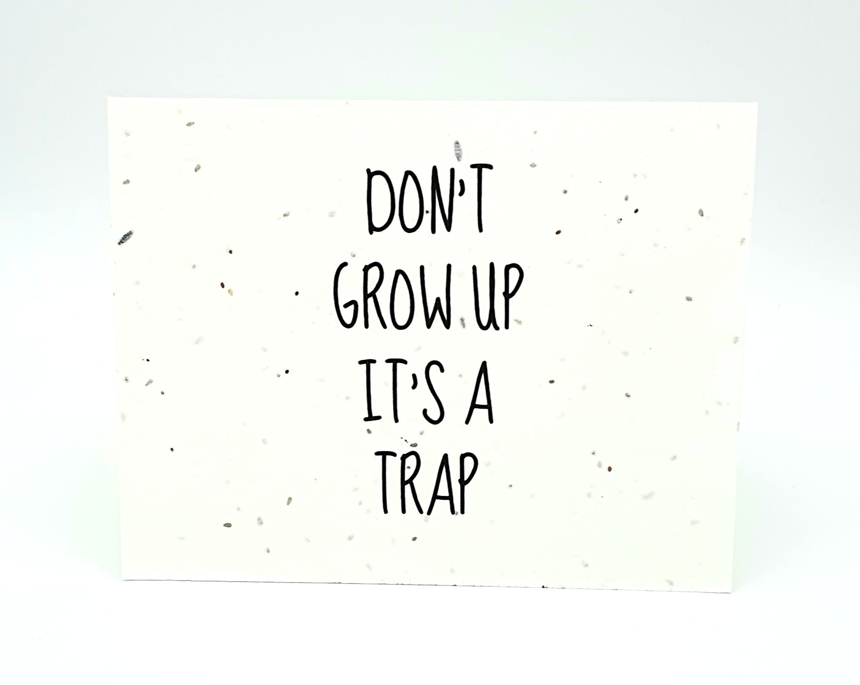 Plantable seed card with "Don't Grow Up It's A Trap"