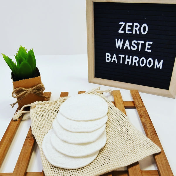 5 pack cotton terry reusable makeup remover pads with mesh laundering bag next to zero waste bathroom letter board.