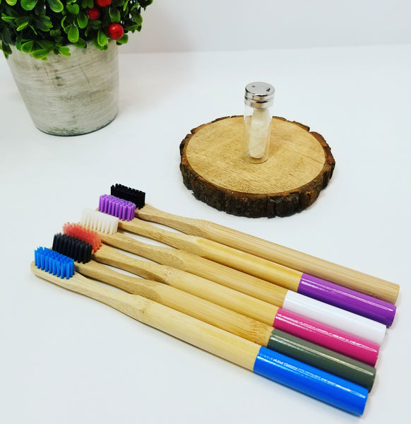 6 different coloured bamboo toothbrushes with compostable corn dental floss in glass container.