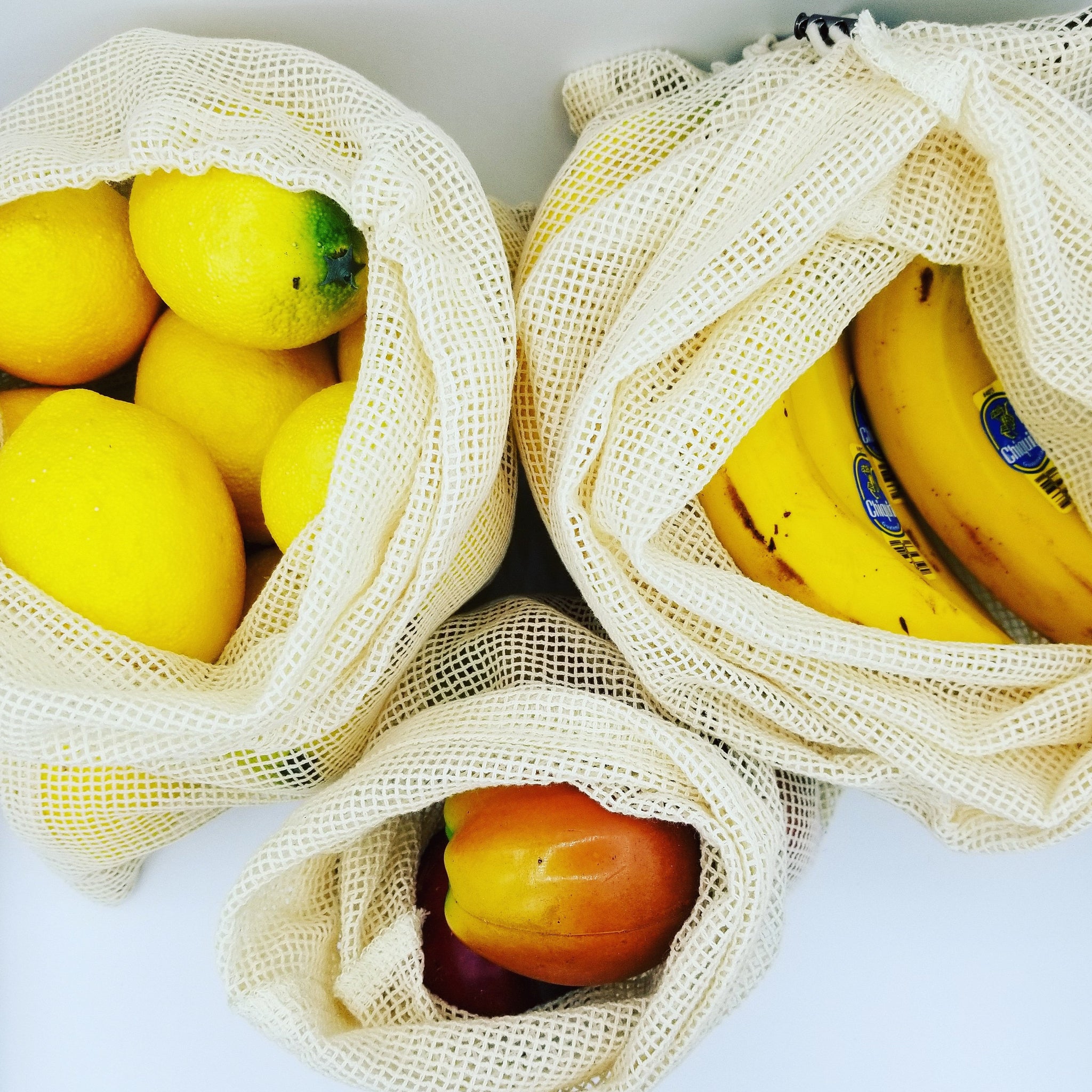 3 Pack Cotton mesh produce bags - small, medium and large size, with fruit in them.